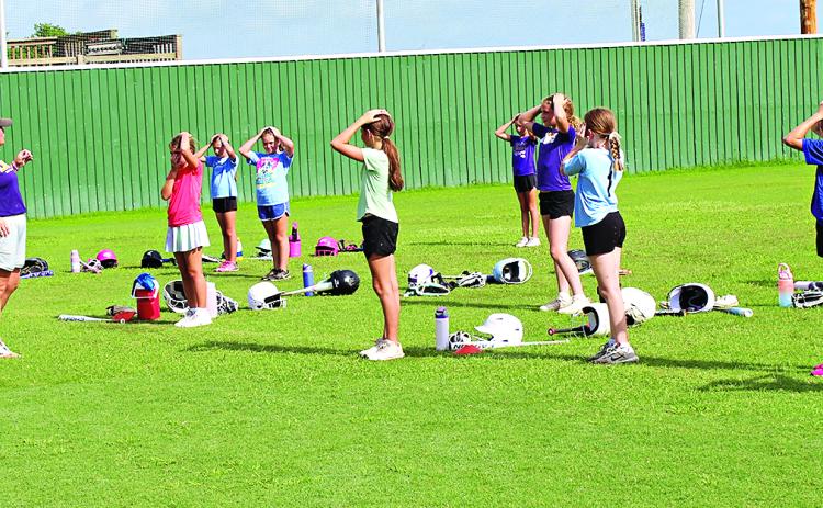 LSUE Softball Coach Meghan Collins leads girls in warm up drills Thursday morning before the camp begins. (Photo by Myra Miller)