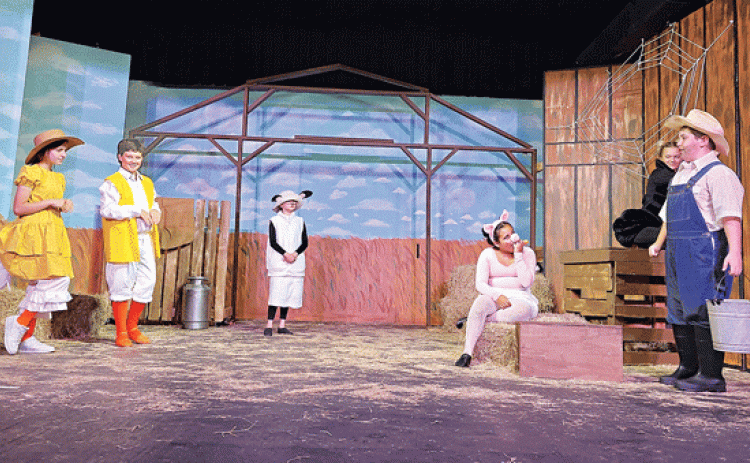 This scene from “Charlotte’s Web” shows some of the barnyard animals at the Zuckerman farm and Lurvy, the farm hand, played by Everett Reppond.  Goose and Gander are played by Elle Soileau and Issack Henderson; Lamb is played by Bailey Fruge. (Submitted photo) 