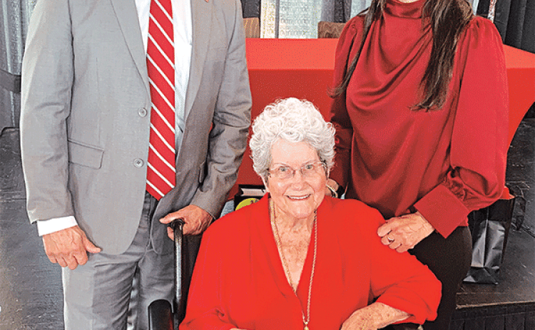 Deanna Habetz,  seated, was presented an official Ragin’ Cajun jersey and named “honorary coach” of the UL Lafayette team after her daughter, Alyson Habetz, right, was announced as the newest head coach. Making the presentations was Dr. Bryan Maggard, UL’s director of athletics. (Photo by Glenn Quebedeaux/Crowley Post-Signal)