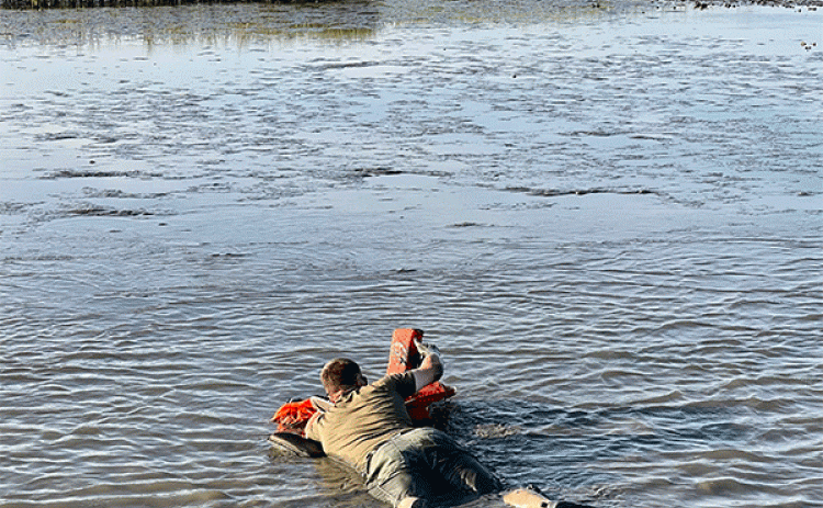 Senior Agent Joshua Segrest makes his way through the mud to get to the stranded boaters. (Louisiana Department of Wildlife and Fisheries photo)
