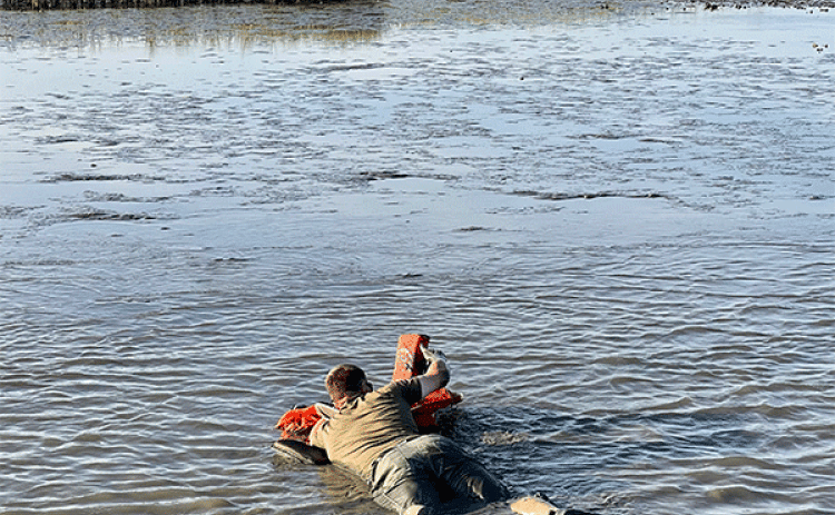 Senior Agent Joshua Segrest makes his way through the mud to get to the stranded boaters. (Louisiana Department of Wildlife and Fisheries photo)
