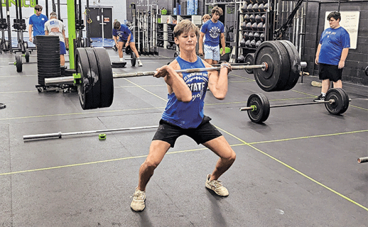Owen Cart, a junior defensive back for the St. Edmund High School football team, builds strength in preparation for the coming season. James Shiver, head football boach, believes if a team has 10 or more players who can power clean 225 pounds or more they stand a good chance of becoming a state title contender. (Photo by Rhett Manuel)