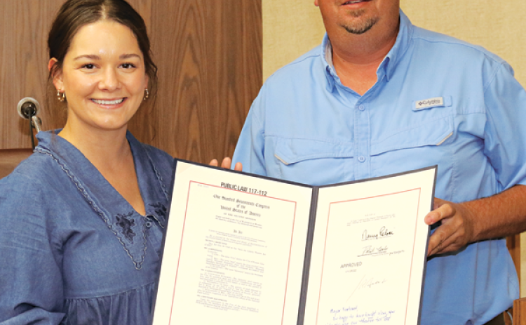 Sarah Dake, a representative from U.S. Sen. John Kennedy’s office, presents a document to Eunice Mayor Scott Fontenot signifying the transfer of the Liberty Theatre Annex from the U.S. Park Service to the city at Tuesday’s Board of Aldermen meeting. (Photo by Harlan Kirgan)