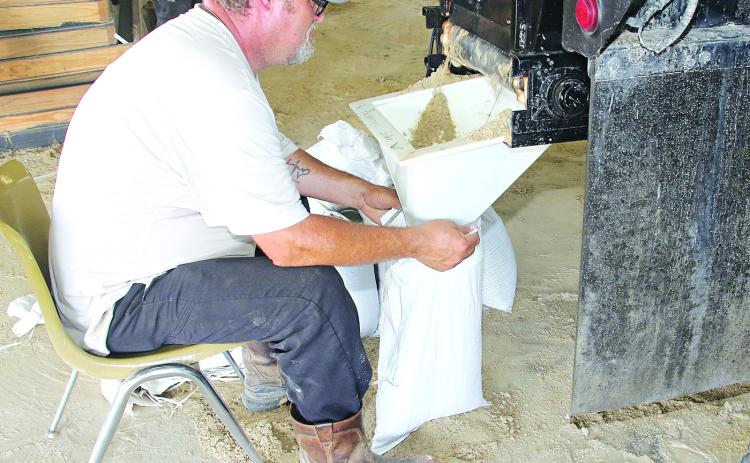 St. Landry Parish Government worker David Courville fills sandbags at the Yambilee Building in Opelousas on Tuesday afternoon. (Photo by Harlan Kirgan.