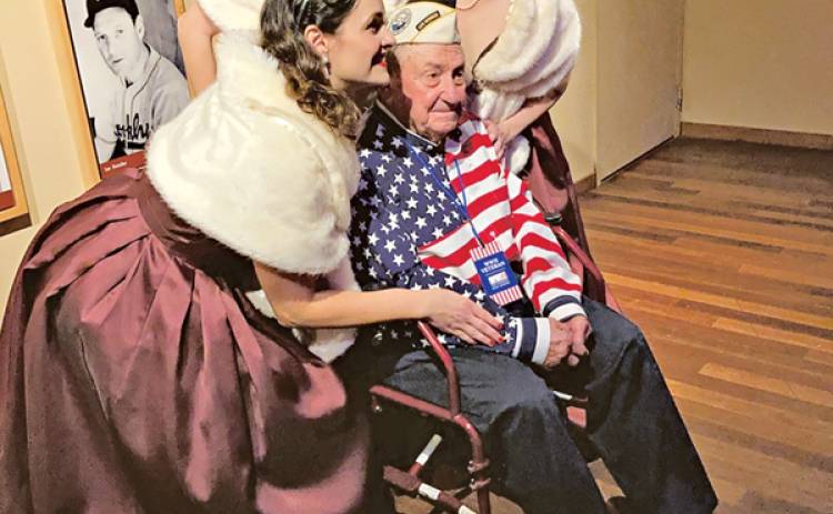 Richard has his photo taken with the National WWII Museum’s Victory Belles, a vocal trio that performs music from the 1940s. Richard visited the museum last year for the 80th anniversary of the attack on Pearl Harbor, and he was the only survivor to attend the event. (Photo courtesy of Connie Figueron)