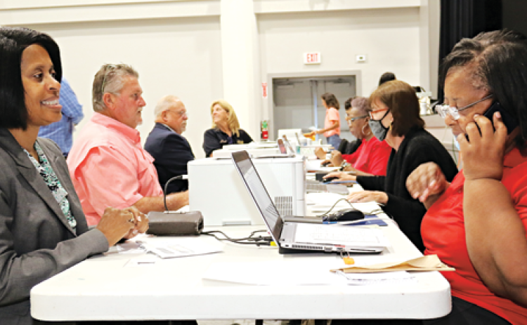 Eunice Alderwoman Germaine Simpson, left, was first in line for qualifying Wednesday morning at the Delta Grand in Opelousas. Cynthia Martin, right, assists Simpson. Also at the table qualifying,  are Carroll Snyder, qualifying for Krotz Springs mayor; Kyle LeBouef, qualifying for Eunice police chief; and Susie Snyder, Krotz Springs police chief. (Photos by Harlan Kirgan)