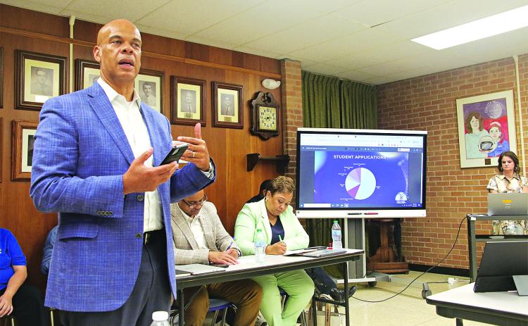Preston Castille, left, president and CEO at Helix Community Schools, speaks at the St. Landry Parish School Board Committee of the Whole meeting on Tuesday about the opening of new school in Opelousas. (Photo by Harlan Kirgan)