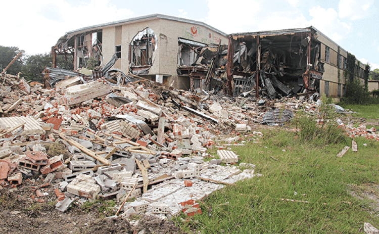 Moosa Memorial Hospital is fast disappearing as demolitions continues. The building was vacant since 2006 and in June St. Landry Parish President Jessie Bellard announced parish government would do the work. Bellard estimated the building is about 80,000 square feet. Much of the debris is being recycled. Bellard said metal is being sold. Bricks and concrete are being processed for road material, he said. (Photo by Harlan Kirgan)