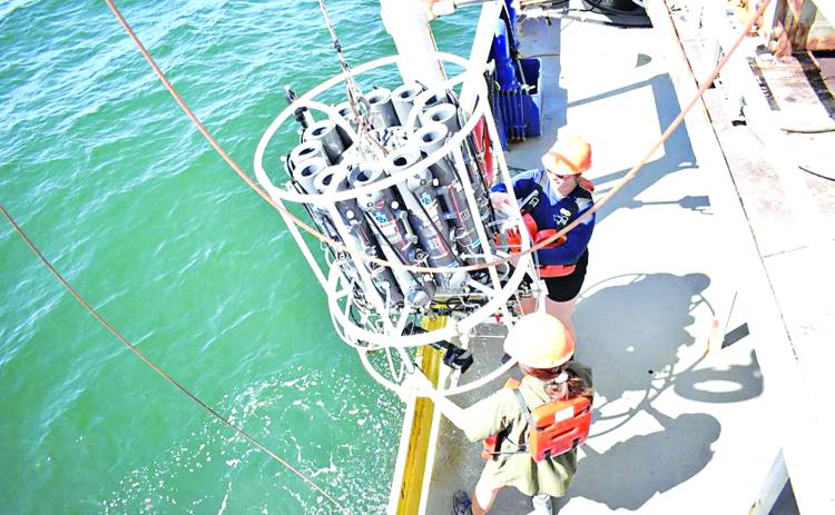 Students Abby Roche and Lily Tubbs retrieve the conductivity, temperature, depth sensor package after profiling dissolved oxygen at a station on the Louisiana Universities Marine Consortium Shelfwide Hypoxia Cruise. (Photo by Cassandra Glaspie | LUMCON/LSU)