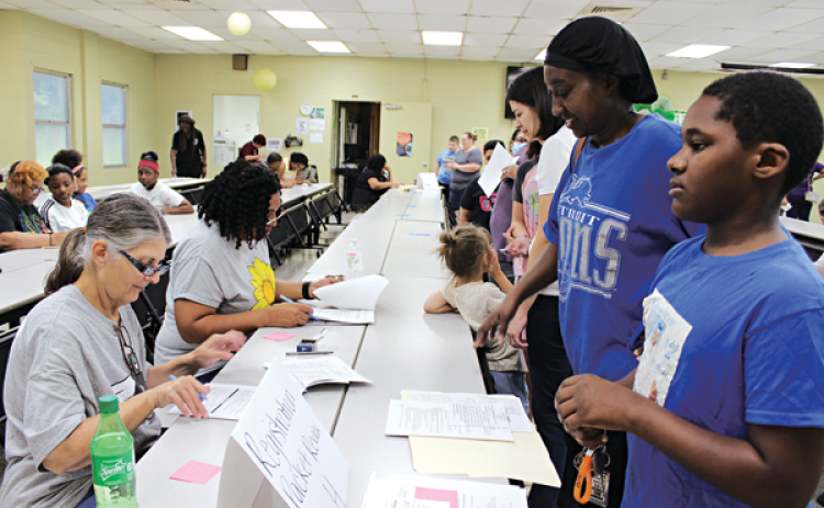 Central Middle School held its fifth and sixth grade school registration Monday. Many students along with their parents or guardians went through the process of registration, paying registration fees, receiving schedules and registering for spirit shirts. At the registration packet review table are Cynthia Guillory, left, and Sheila Janice. In front of the table are Brycen Honore, a fifth grader, and his mother Lisa LaFleur. The first day for public schools in Eunice is Aug. 11.  (Photo by Myra Miller)
