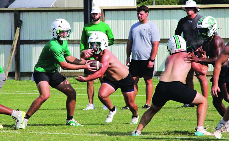 Senior quarterback Montana Brown handing ball off to senior running back Parker Pedigo during a Bobcat fall camp session. (Photo by Rhett Manuel)