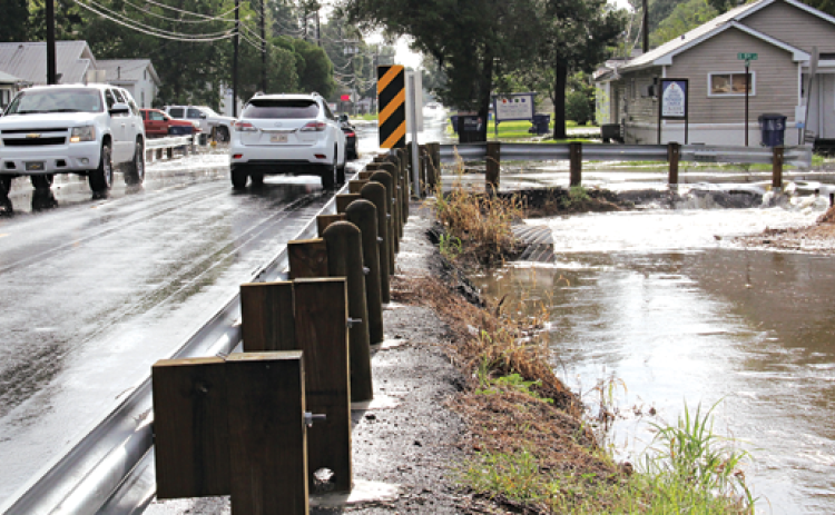Water rolls off South 5th Street at the intersecton with West Maple Avenue during Tuesday’s storm that flooded many streets in Eunice. (Photo by Harlan Kirgan)