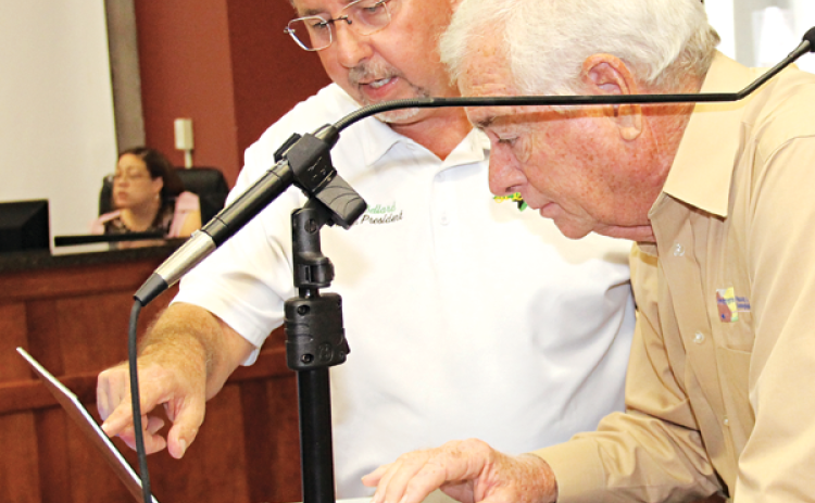 St. Landry Parish President Jessie Bellard, left, and demographer Mike Hefner look over voting precincts on a computer during Wednesday’s Parish Council meeting. Voters are receiving voter identification cards and if they questions should call the Registrar of Voters Office. (Photo by Harlan Kirgan)