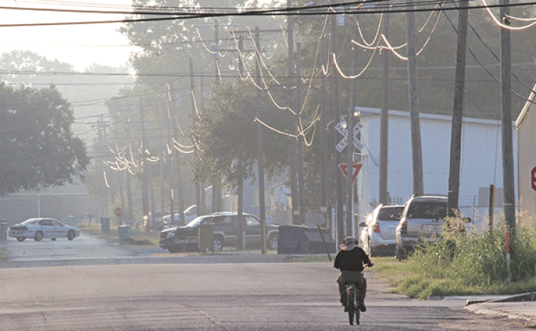 Early morning temperatures in the low 70s last week made riding a bicycle comfortable. This  bicycle rider was on East Vine Street at about 7 a.m. Wednesday. (Photo by Harlan Kirgan)