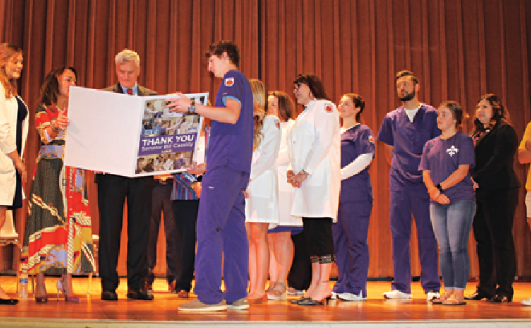 U.S. Sen. Bill Cassidy looks at a “Thank You” from LSUE during a presentation on Friday of a $1 million grant to upgrade LSU Eunice’s Allied Health laboratory equipment. Third from left, is Chancellor Nancee Sorenson. (Photo by Myra Miller )