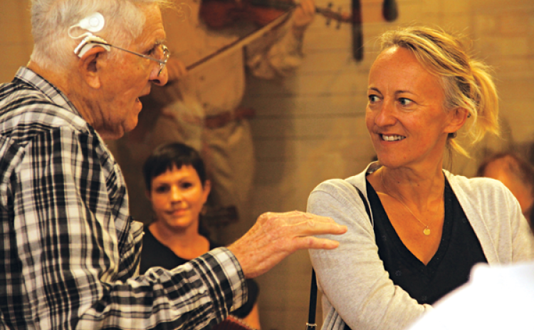 Retired accordion-maker Larry Miller, left, talks with Barbara Boltoukhine, of France, at the CFMA Cajun Music Hall of Fame and Museum on Sunday. Scalamogna is a representative for the Louisiana Office of Tourism. In the background is Sarah Savoy, who performed with Cameron Fontenot. (Photo by Harlan Kirgan)