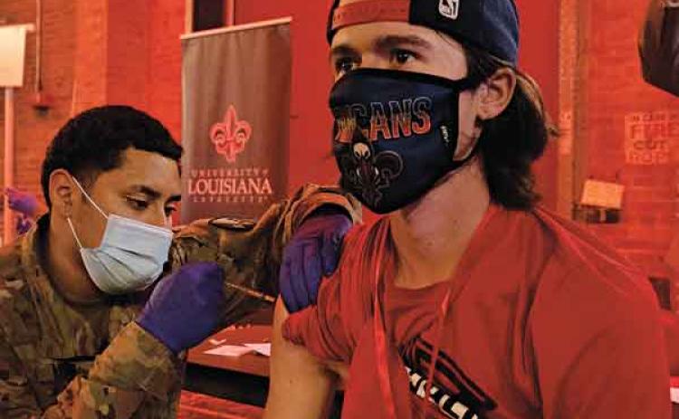 A member of the Louisiana National Guard administers a COVID-19 vaccine to a UL Lafayette student at the campus’ testing and vaccination center last week in Burke-Hawthorne Hall. (Photo by  Doug Dugas / University of Louisiana at Lafayette)