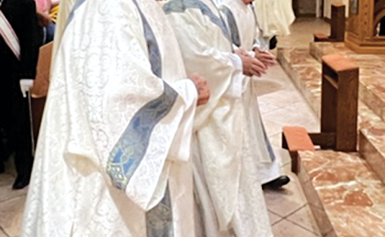 The Rev. Mitch Guidry, center, processes into Our Lady, Queen of All Saints Church. Also pictured are Deacon Chuck Ortego (left) and Deacon Ben Soileau (right). (Photo by Tony Marks/Ville Platte Gazette)