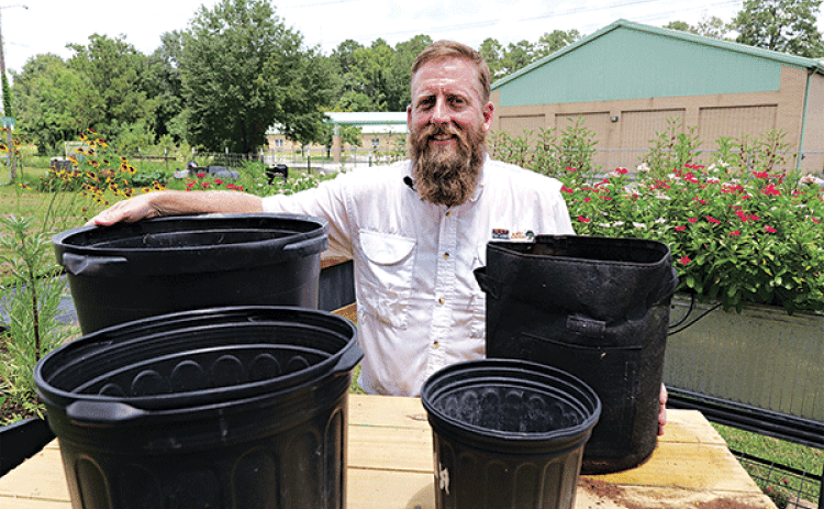 LSU AgCenter horticulture agent Will Afton stands with some different types of containers that can be used for gardening. (Photo by Randy LaBauve/LSU AgCenter)