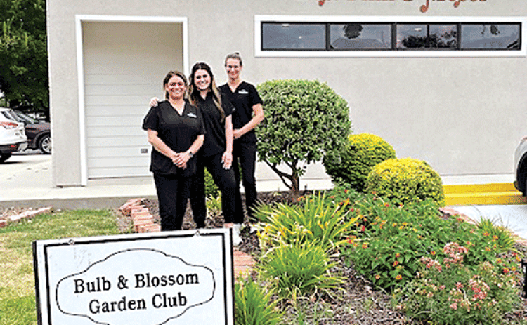 The Bulb & Blossom Club of Eunice awarded the August Business Yard of the Month to Drs. Fink & Moser located at 301 South 2nd. The landscaping features vinca, coleus, day lilies, foxtail ferns and a variety of shrubbery.  From left are Kylie Doucet, Katelyn Smith and Sadie Carrier. (Submitted photos)