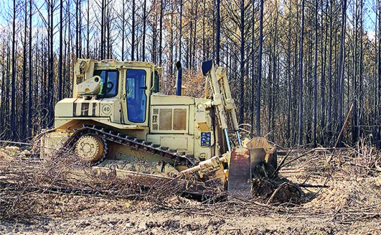 Soldiers from the Louisiana Army National Guard’s 528th Engineer Battalion use bulldozers to move burnt forestry and clear a firebreak near Pirate’s Cove in Florien on Aug. 29,. The Pirates Cove area caught fire on Aug. 25 and Louisiana Army National Guard aviators helped with the initial response. (U.S. Army National Guard Photo by Staff Sgt. Noshoba Davis)
