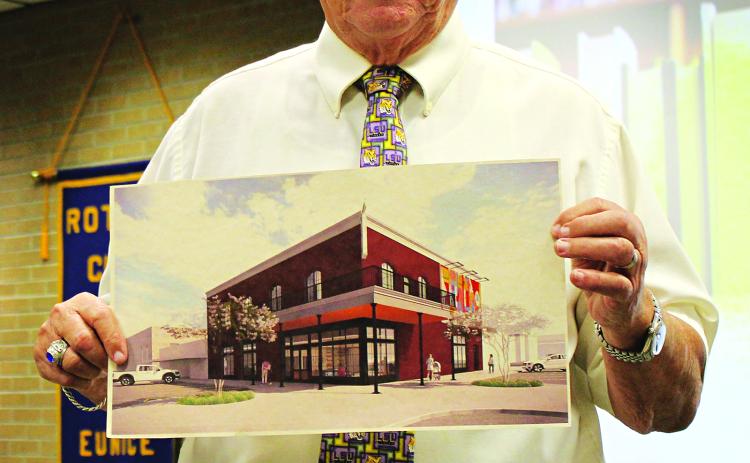Tony Baltakis holds up an artist’s rendition of the future Eunice Public Library. He was the guest speaker Wednesday at the Rotary Club meeting. (Photo by Myra Miller)