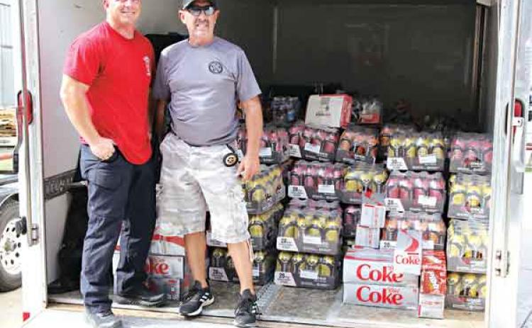 Ryan Daville, left, and Danny Soileau are with a load of drinks on Tuesday afternoon at the Central Fire Station in Eunice. Soileau, with the Eunice City Marshal’s Office, was going to drive the trailer load of supplies to the hurricane-damaged area. Daville is a Eunice firefighter. (Photo by Harlan Kirgan)