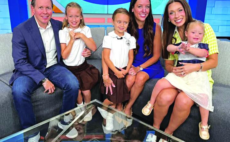 Emery Tanner is the daughter of Michael and Julia Tanner.  Michael is a Eunice native and is the son of Brian and Becky Tanner of Eunice. Also shown are siblings 9-year-old Ryleigh Tanner and 6-year-old Ainsley Tanner. Acadiana Live anchor Taylor Trache, right, holds Emery.