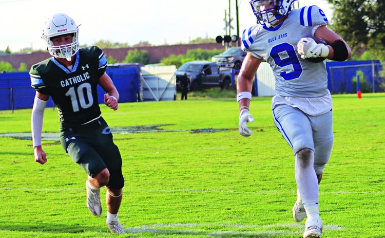 Max Smith, a sophomore tight end, evades a Catholic Pointe Coupee defender in the joe Nagata Jamboree. (Photos by Amy Myers)