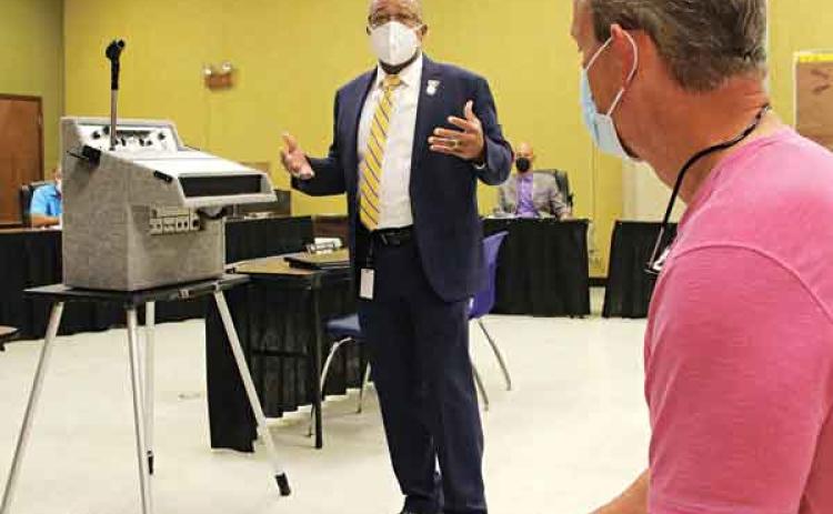 Patrick Jenkins, standing, St. Landry Parish school superintendent, addresses a committee of the whole meeting Thursday on capital improvement plans. At right is Lyn Henley, a consultant from Volkert Inc. (Photo by Harlan Kirgan)