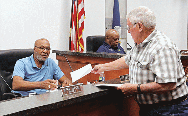 St. Landry Parish Council member Wayne Ardoin, right, hands out a letter he wrote to Council member Jimmie Edwards, of Eunice, at a meeting Wednesday in Opelousas. In the background is Council Chairman Jerry Red. (Photo by Harlan Kirgan)