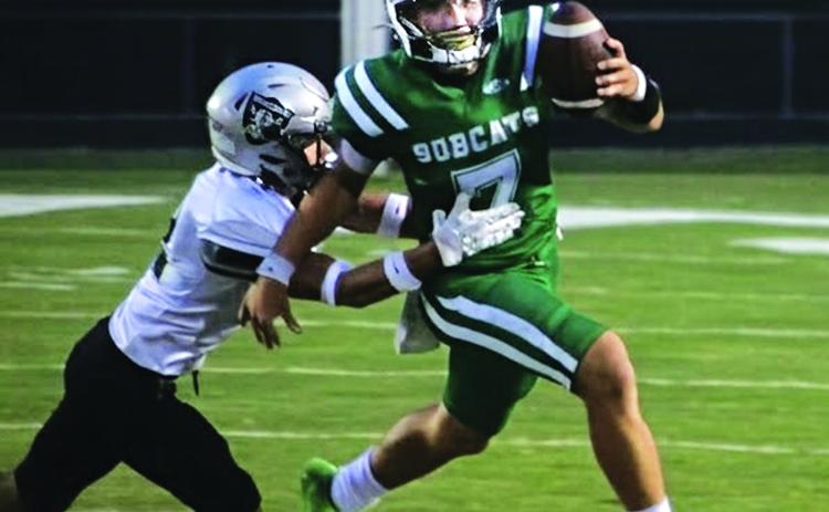 Bobcat quarterback Montana Brown tries to elude a Northwest tackler. (Photo by Rhett Manuel)