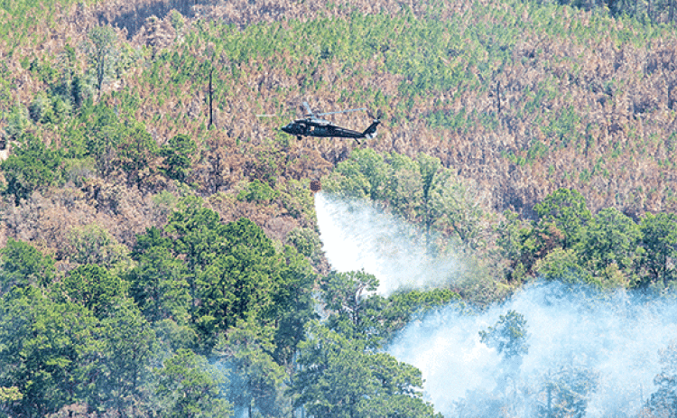 Aviators with the Louisiana National Guard and Alabama National Guard respond to wildfires in Vernon Parish on Aug. 31. Aviators use a bambi bucket to retrieve water and splash nearly 600 gallons of water at a time on the fires. (U.S. Army National Guard photo by Staff Sgt. Noshoba Davis)