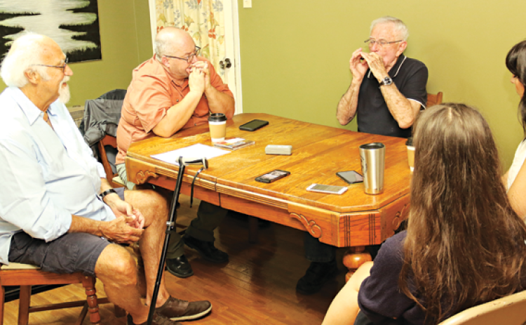 Jerry Devillier, third from left, makes a point using his harmonica during an interview for a UL Lafayette traditional music class. The interview is to be included in archives at UL Lafayette. From left, are Michael Doucet, Dr Chad Huval, Devillier, Renee Reed and Julie Babineaux. (Photos by Harlan Kirgan)