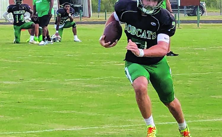 Senior quarterback Montana Brown scrambles for yardage. (Photo by Rhett Manuel)