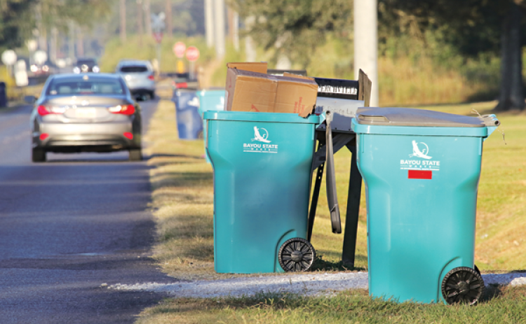 Bayou State Waste trash cans are on Perchville Road on Thursday. A dark blueWaste Connections can be seen in the background. The change in trash pickup service was chaotic last week. Richard LeBouef, executive director of the St. Landry Parish Solid Waste Commission, said the service should improve starting Monday. (Photo by Harlan Kirgan)