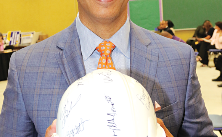 Preston Castille, Helix Community Schools president, holds a hard hat signed by St. Landry Parish School Board members Thursday. The School Board approved a charter school application by Helix Community Schools. Two schools are planned for Opelousas. (Photo by Harlan Kirgan)