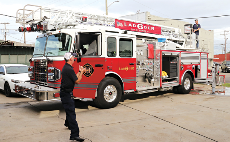 Eunice Fire Chief Mike Arnold, left, and firefighter Robert Avery work with the department’s new 75-foot ladder truck behind the Central Fire Station. (Photos by Harlan Kirgan)