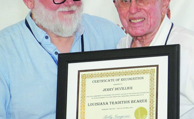 Jerry Devillier, right, was recognized as a Louisiana Tradition Bearer during Festivals Acadiens et Créoles on Saturday in Lafayette. Presenting the certificate is John Sharp, assistant director for research at Center for Louisiana Studies, University of Louisiana-Lafayette. Devillier, 86, of Eunice, was described as the “...only one true Cajun harmonica player” during the ceremony. (Photos by Harlan Kirgan)
