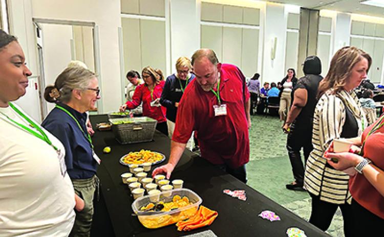Attendees of the LSU AgCenter’s seventh annual Louisiana Farm to School Conference sample local satsumas provided by Ben & Ben Becnel Inc. (Photo by Jacey Wesley/LSU AgCenter)
