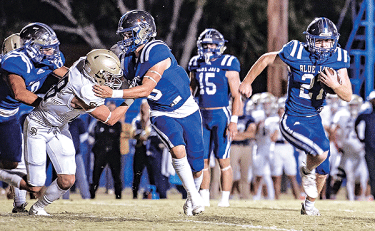 Henry Summerlin runs behinds a wall of St. Edmund blockers in the 57-7 win over Sacred Heart of Ville Platte on Friday. Summerlin is closing in on posting 1,000 yards rushing for the season. (Photo by Dwight Jodon)