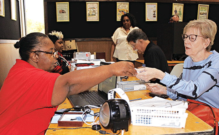 Candice Soileau of Eunice, at right, is getting ready to early vote at Eunice City Hall. Assisting her is Commissioner Cheryl Martin.