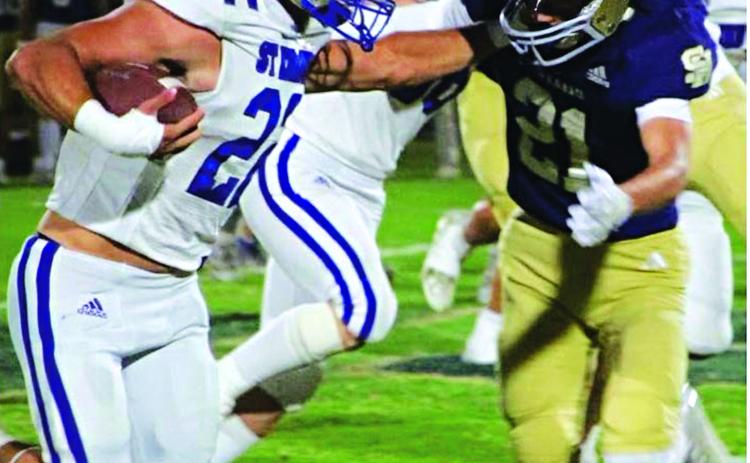 St. Ed’s Wyatt Dubois stiff arms a Sacred Heart defender on the way to scoring a touchdown in last Friday’s 58-36 win over the Trojans in district play. (Photo by Sports Editor Rhett Manuel)
