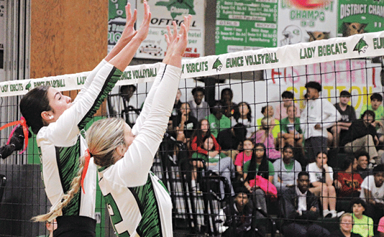 Eunice High volleyballers Madelyn Smith an Brooklyn Darbonne stretch to block a ball.