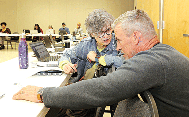 St. Landry Parish School Board member Mary Ellen Donatto confers with Lyn Kenley of Volker during Monday’s retreat. (Photo by Harlan Kirgan)