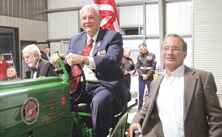 Maj. Gen. Ronald J. Richard sits atop his grandfather’s tractor that was restored by Tom Klumpp, right, owner of Klumpp Equipment on the Basile Eunice Highway. Klumpp was one of the hosts for a Marine Corps Birthday Ball held Nov. 10 to celebrate the 246th birthday of the United States Marine Corps. (Ville Platte Gazette photo by Tony Marks)