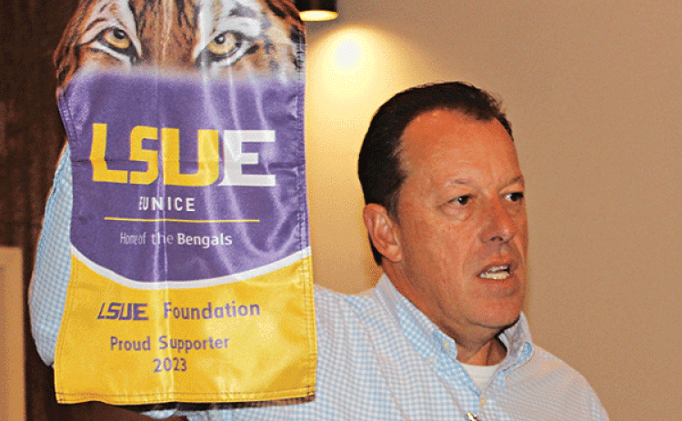 Kip Bertrand holds up a new 2023 LSUE Foundation flag that businesses can purchase for $200 each. Bertrand’s goal is to sell 200 to beat last year’s sales of 100. For more information, or to purchase a flag, call Ray Zorn at LSUE at 337-550-1281. (Photo by Myra Miller)