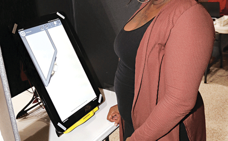 Trovette Martin, a clerk at the Eunice City Hall poll, waits for voters Tuesday afternoon. (Photo by Harlan Kirgan)