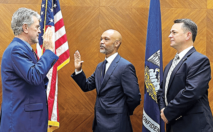From left, St. Landry Parish Clerk of Court Charles Jagneaux administers an oath of office to Ogden Pitre as District Attorney Chad Pitre looks on. (Submitted photo)