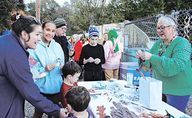 Angela Huckaby with CDA Court 208 demonstrates how to craft reindeer antlers at the Eunice Community Garden Christmas Festival Thursday. From left are Gabriel Daire, Branson Daire, Gina Daire, Jayla Mickens, Michael Laird and Jax Laird. Huckaby also had crafts of Christmas ornaments.Turn to Page 10 for more photos from the festival. (Photo by Myra Miller)